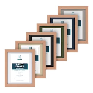 May include: A series of six rectangular light wood photo frames arranged in a diagonal stack. Each frame features a white mount and a central display card with the text PHOTO FRAMES WITH MOUNT, Multiple sizes & colours to choose from.