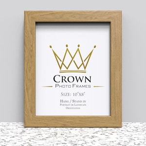 May include: A natural wood picture frame with a crown logo and the text "CROWN PHOTO FRAMES" and "SIZE: 10"X8"". The frame can be hung or stand in portrait or landscape orientation.