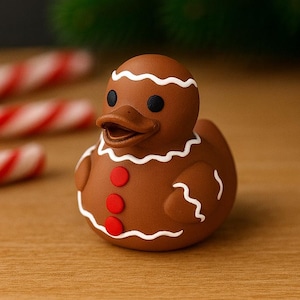 Könnte beinhalten: Eine braune Gummi-Ente in Form eines Lebkuchenmannes, verziert mit weißen Zuckerguss-Details und roten Knöpfen. Die Ente steht auf einer Holzoberfläche, mit Zuckerstangen und einem Weihnachtsbaum im Hintergrund.