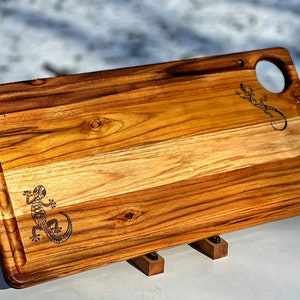 Large teak cutting board with lizard engravings