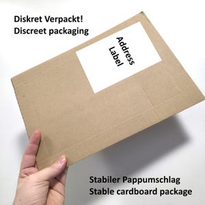 May include: A rectangular brown cardboard shipping envelope featuring a white rectangular address label. The text on the package reads: Diskret Verpackt! Discreet packaging, Address Label, and Stabiler Pappumschlag Stable cardboard package.
