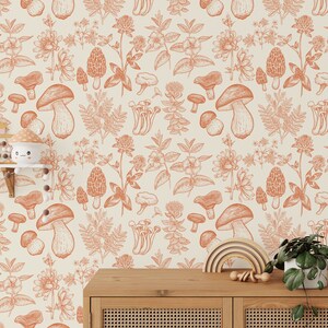 May include: A seamless pattern wallpaper featuring a repeating design of mushrooms and wildflowers in shades of orange and brown on a cream background.