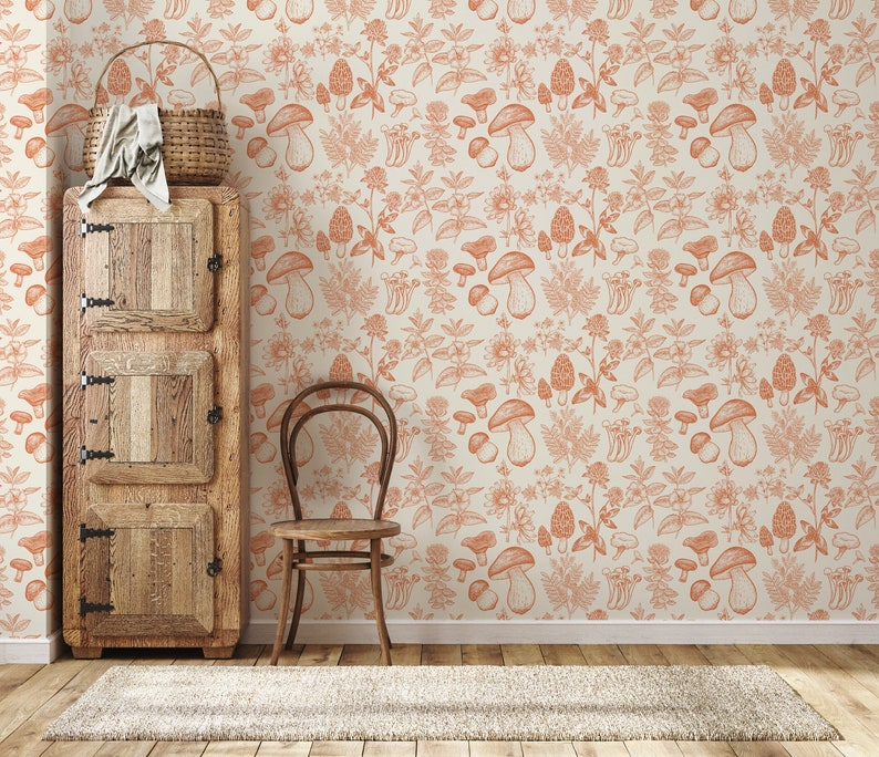 May include: A vintage-style wooden cabinet with two doors and a drawer, a wooden chair, and a beige rug in front of a wall with a repeating pattern of orange mushrooms and foliage.