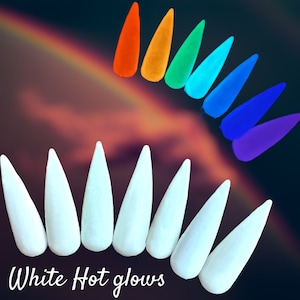 May include: White hot glow-in-the-dark nail tips in a stiletto shape. The tips are arranged in a semi-circle with the text "White Hot glows" below them. There are also 8 colorful nail tips in the background, arranged in a semi-circle.