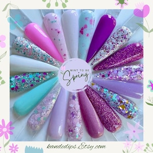 May include: A color wheel of 15 different nail polish colors. The colors are mostly shades of pink, purple, and blue with glitter. The text "MINT TO BE Spring" is in the center of the wheel.