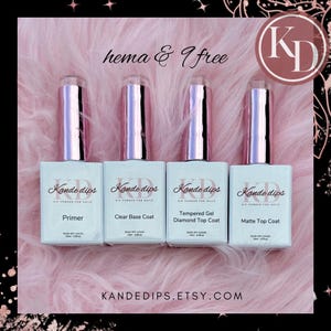 May include: Four clear bottles with pink lids and white labels. The labels read "Kande dips Dip Powder for Nails" and list the product names: "Primer", "Clear Base Coat", "Tempered Gel Diamond Top Coat", and "Matte Top Coat". The text "hema & 7 free" is written above the bottles. The text "KANDEDIPS.ETSY.COM" is written below the bottles.