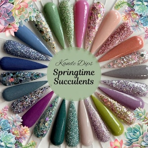 May include: A collection of nail dip samples in various colors, including blue, green, pink, and purple, with glitter and solid finishes. The samples are arranged in a circular pattern, with the text "Kande Dips Springtime Succulents" in the center.