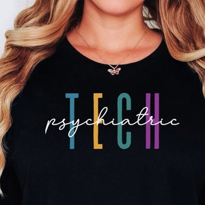 Op de afbeelding: Zwart T-shirt met de tekst "psychiatric tech" in kleurrijke letters.