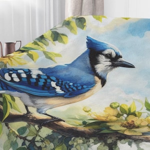 May include: A blue jay bird perched on a branch with yellow flowers. The bird is surrounded by green leaves and a watercolor background.