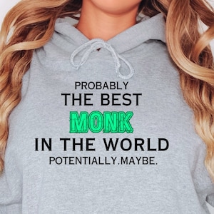 Puede incluir: Una sudadera gris con un gráfico verde que dice "Probablemente el mejor monje del mundo. Potencialmente. Tal vez."