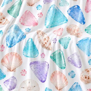 Puede incluir: Una manta blanca con un patrón repetitivo de conchas marinas, dólares de arena y diversas formas triangulares y circulares estilo acuarela en tonos azul, turquesa, morado, rosa y bronceado esparcidos por la tela.