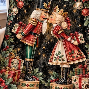 以下が含まれることがあります： くるみ割り人形と女王がキスをしているクリスマスのイラストが描かれた黒いブランケット。暗い背景に、赤と緑のギフトボックス、ヒイラギの葉、松ぼっくり、赤いリボン、金色のオーナメントがデザインされています。