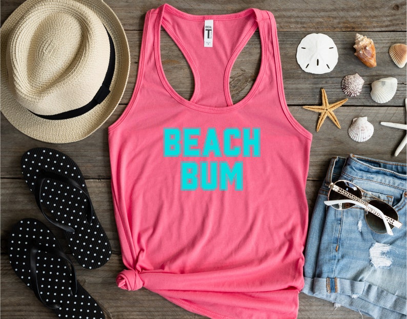 May include: Pink tank top with the text "Beach Bum" in turquoise blue lettering.