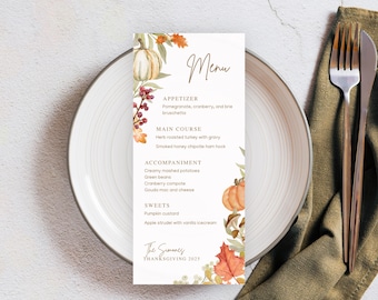 May include: Thanksgiving menu card with watercolor pumpkins, leaves, and berries. The menu includes appetizers, main courses, accompaniments, and sweets. The card is on a white plate with a fork and knife.