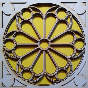 May include: A laser-cut wooden artwork with a geometric rose window design. The light brown frame surrounds a yellow background, with the design made up of layered, intricate shapes. The artwork is suitable for wall decor.
