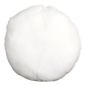 May include: A round, white pillow with a soft, textured surface. The pillow is made of a light-colored fabric and appears to be filled with a fluffy material. The pillow is a solid color and has a simple design.