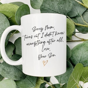 May include: White ceramic mug with a black handwritten message that reads "Sorry Mom, Turns out I didn't know everything after all. Love, Your Son" with a gold heart.