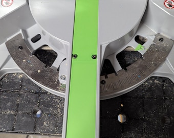May include: A miter saw with a bright green guide and a silver blade. The saw has a black base and is designed for cutting wood at various angles. The blade guard is visible, and the saw appears to be in good condition.