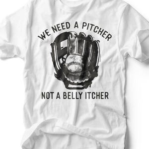 Puede incluir: Camiseta blanca con un gráfico en blanco y negro de un guante de béisbol sosteniendo una pelota. El texto de la camiseta dice: "WE NEED A PITCHER NOT A BELLY ITCHER."