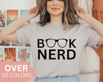 May include: A grey t-shirt with the text "BOOK NERD" in black lettering and a pair of black glasses graphic.