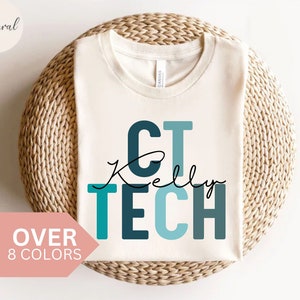 Puede incluir: Una camiseta blanca con el texto "CT Kelly TECH" en azul y verde azulado. El texto está en una fuente de bloque.