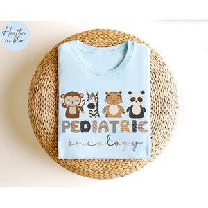 May include: Light blue t-shirt with a graphic of animals and the text "PEDIATRIC oncology".