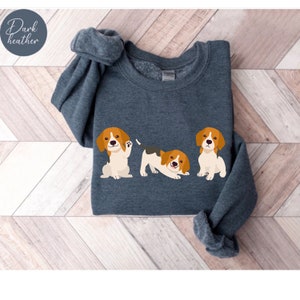 May include: A dark heather grey sweatshirt with a graphic of three beagle puppies in different poses. The puppies are brown, white, and black.