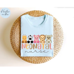 Puede incluir: Una camiseta azul claro con un gr&aacute;fico de cinco animales de dibujos animados y el texto "NEONATAL nurse".