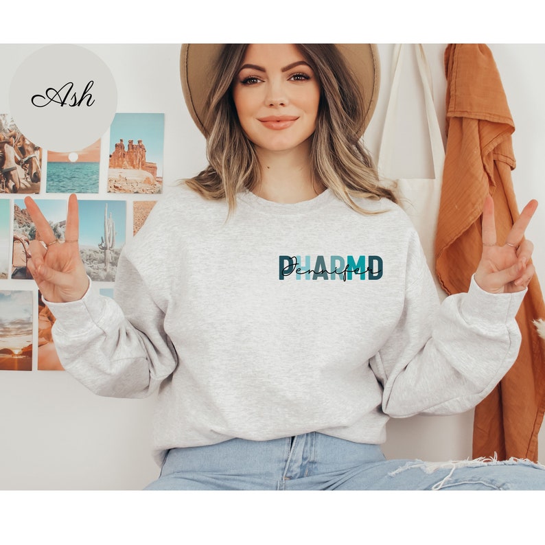 May include: A gray sweatshirt with a blue and green graphic that says "PHARM'D" on the front.