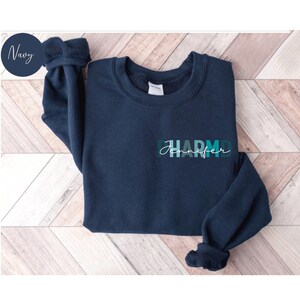 May include: A navy blue sweatshirt with a teal and green gradient design that says "Jennifer PharmD" on the front.