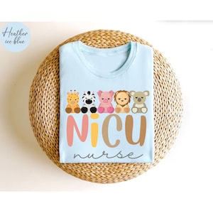 May include: Light blue t-shirt with a graphic of a line of cute animal characters and the text "NICU nurse".