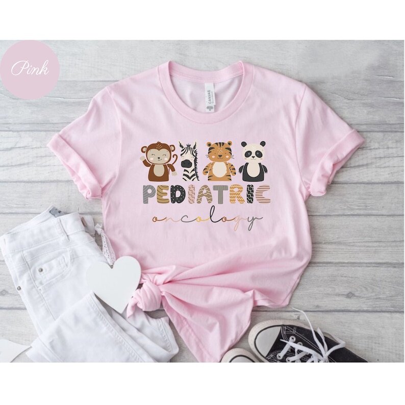 May include: Pink t-shirt with a graphic of animals and the text "PEDIATRIC ONCOLOGY".