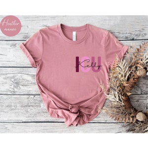 May include: A heather mauve t-shirt with the text "I love you Kelly" in pink, purple, and burgundy letters.