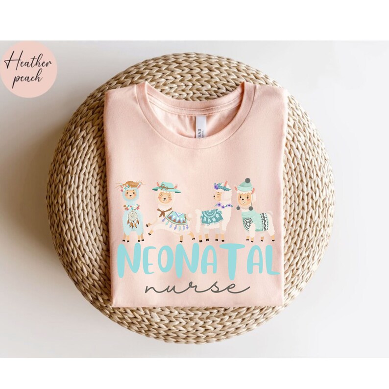 Pu&ograve; includere: Una maglietta rosa con una grafica di cinque lama che indossano cappelli e il testo "NEONATAL nurse" in blu.