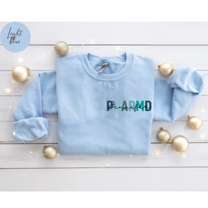 May include: Light blue sweatshirt with the text "Jennifer" and "D.A.R.M.D." in colorful letters.