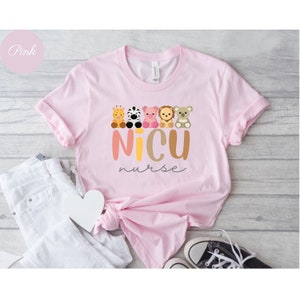 May include: Pink t-shirt with a graphic of a line of cute animal characters and the text "NICU nurse".