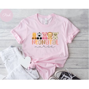 Puede incluir: Camiseta rosa con un gr&aacute;fico de cinco animales de dibujos animados y el texto "Neonatal Nurse".