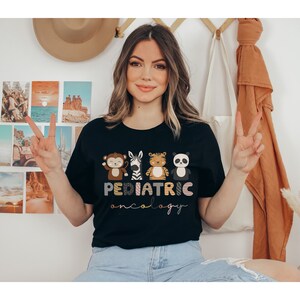 May include: A black t-shirt with a graphic of four cartoon animals and the text "PEDIATRIC ONCOLOGY".