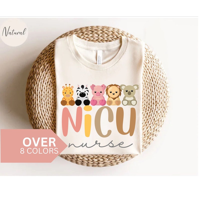 May include: A white t-shirt with a graphic of a line of cartoon animals, including a giraffe, zebra, pig, lion, and koala. The text "NICU nurse" is printed below the animals in pink, yellow, brown, and white.