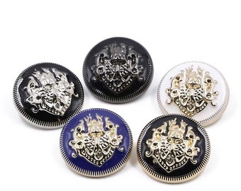 May include: Five decorative buttons with a gold-colored design on a white background. The buttons are round and have a black, white, blue, and silver finish.