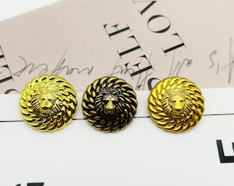May include: Three round metal buttons with a lion head design. The buttons are gold, black, and gold.