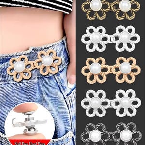 Peut inclure: Boutons de jean en forme de fleur, disponibles en or, argent et bronze, chacun avec une perle centrale. Les boutons sont présentés attachés à un jean en denim. L'image montre également un outil pour une installation facile. Le texte sur l'image indique "Nail Free Hand Press."