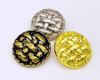 May include: Three decorative buttons with a woven design. The buttons are gold, silver, and black.