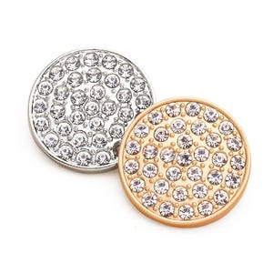 以下が含まれることがあります： 小さな透明なラインストーンで覆われた、丸い装飾的な金属製のディスクが2つ。1つのディスクは銀色で、もう1つは金色です。