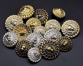 May include: A collection of gold and silver lion head buttons with a rope-like design around the edge.