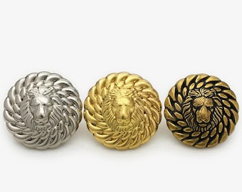 May include: Three round metal buttons featuring a lion head design. The buttons are gold, silver, and black.