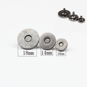May include: Three silver magnetic snap closures in different sizes: 18mm, 14mm, and 10mm. The snaps have a textured, patterned surface.
