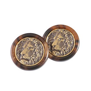 May include: A pair of round, brown and gold cufflinks featuring a lion head design.