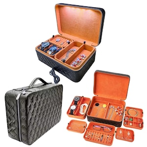 May include: Black quilted jewelry box with a built-in light and multiple compartments for storing jewelry, watches, and other accessories. The box is open and the compartments are filled with jewelry.