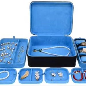 May include: A blue velvet jewelry box with multiple compartments for storing necklaces, earrings, bracelets, and watches. The box has a hinged lid and a soft blue interior.